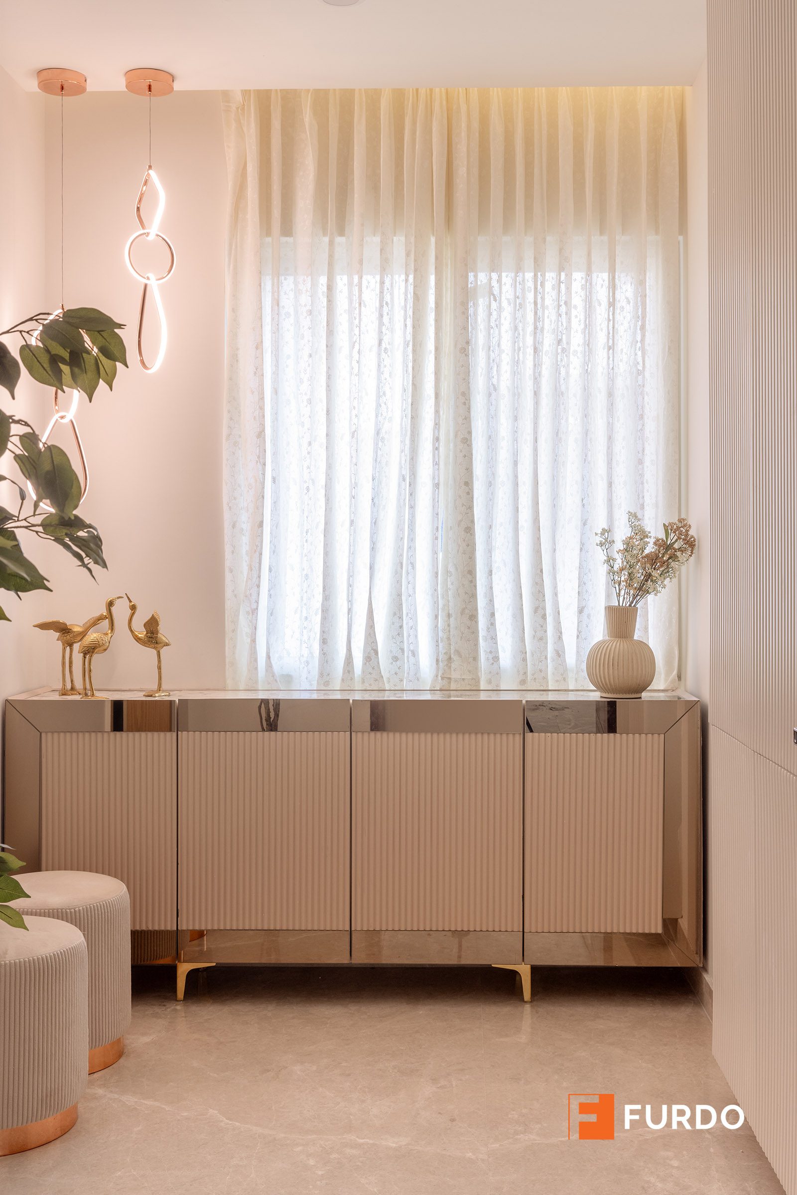 Luxury sideboard and console storage design Hyderabad — a low storage bank beneath a window in the living space at Auro Kohinoor