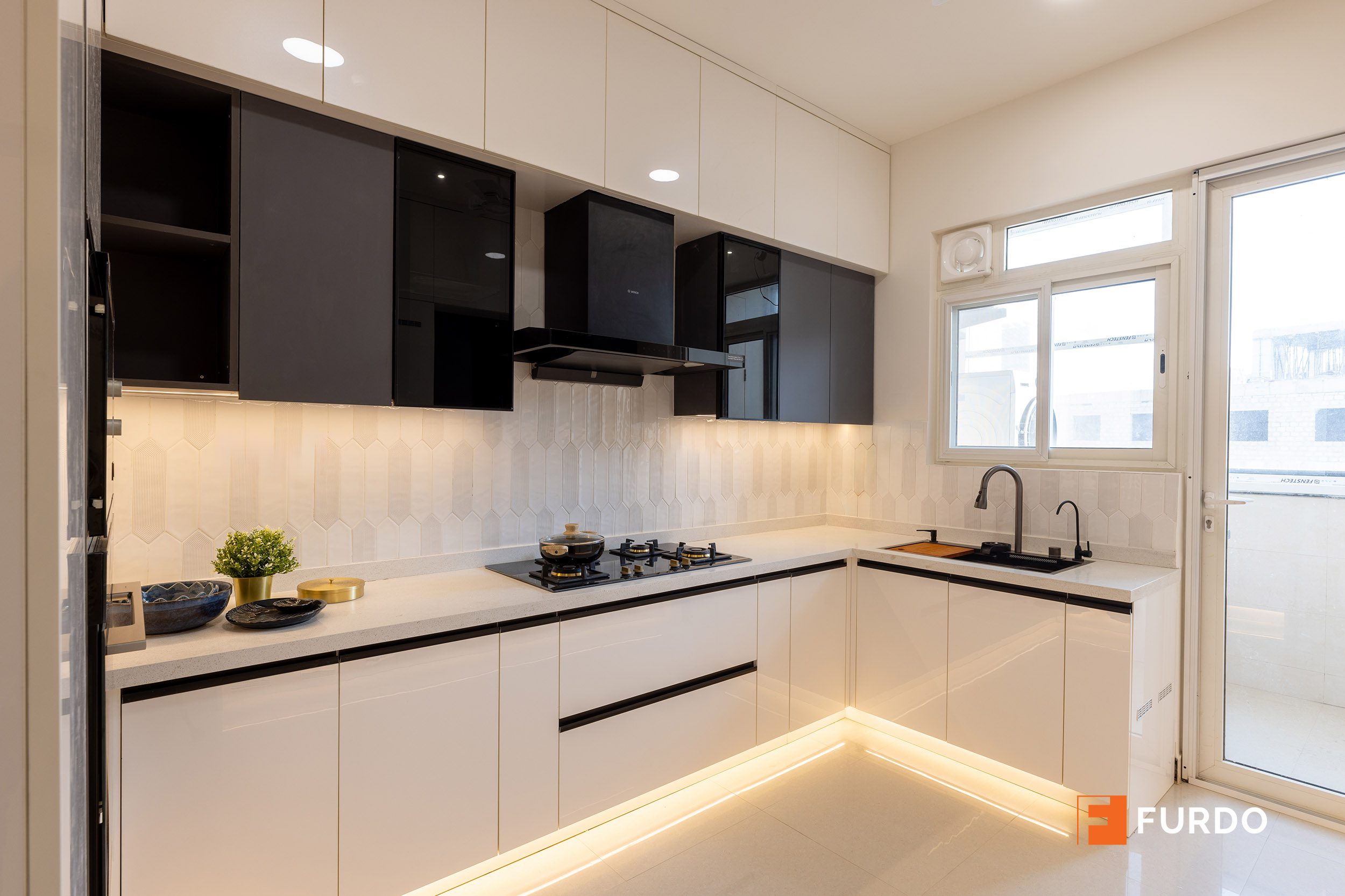 Luxury modular kitchen interior design Hyderabad — Auro Kohinoor, glossy black-and-white cabinetry in an L-shaped layout