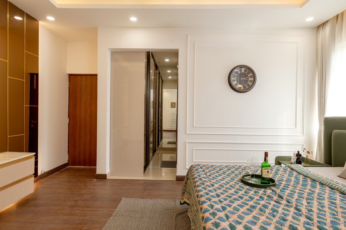 Luxury bedroom wardrobe design Hyderabad — a wardrobe run with a mirrored panel lining the passage into the bedroom at Auro Kohinoor