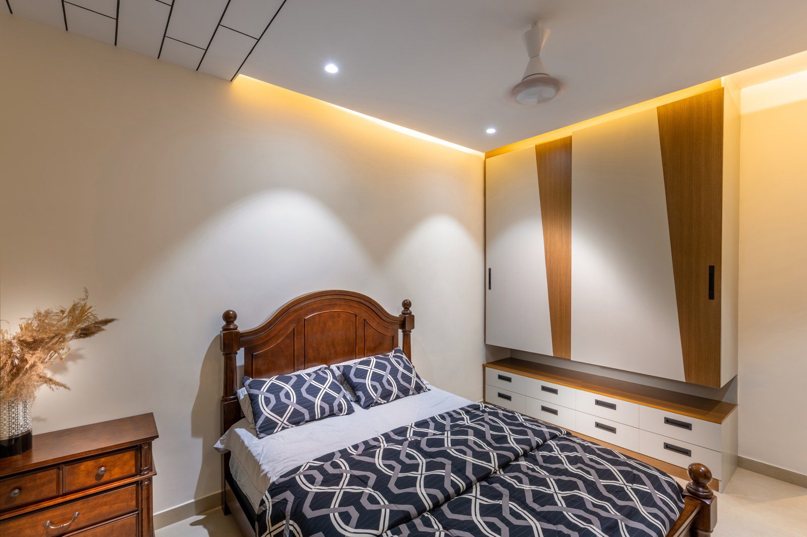 Primary bedroom interior design with wooden bed and warm lighting in a Bangalore villa